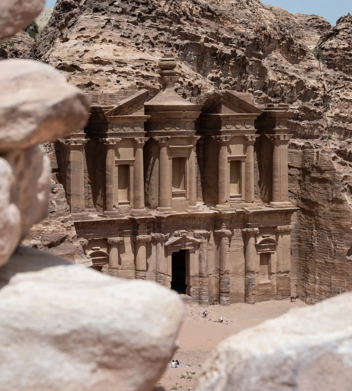 The rock-cut facade of Ad Deir (the Monastery) framed by boulders, Petra, Jordan